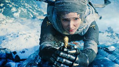 Galadriel hält einen Schwergriff umklammert. Sie trägt eine Rüstung und ein Kopftuch. Hinter ihr liegt eine eisige Landschaft.