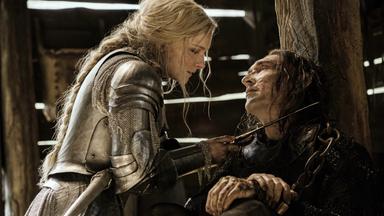 Galadriel steht Adar in einer Scheune gegenüber. Sie trägt eine Rüstung und hält ihm einen Dolch an den Hals.