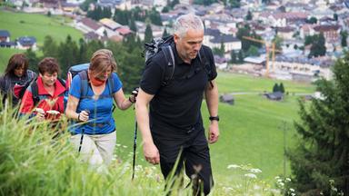  Pilger:innen auf einem steilen Wanderweg in den Bergen