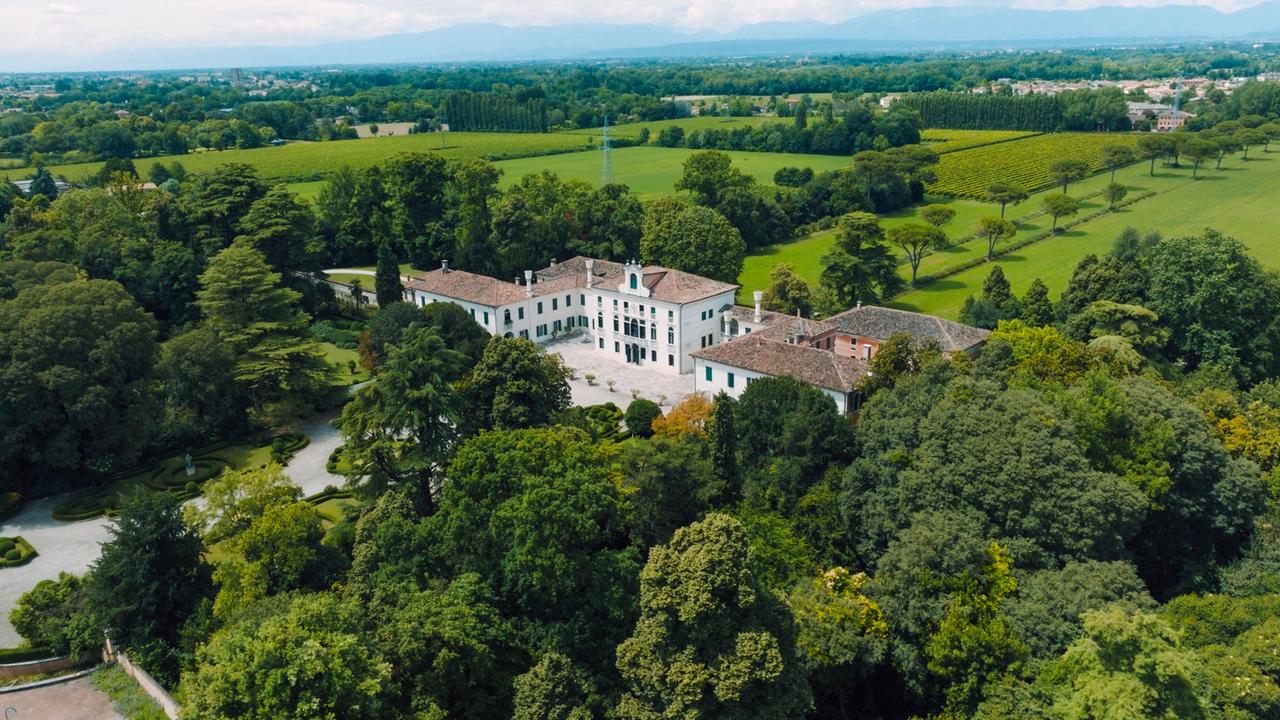 Luftaufnahme der Villa Tiepolo Passi, umgeben von gepflegten Gärten und einer weiten, grünen Hügellandschaft.