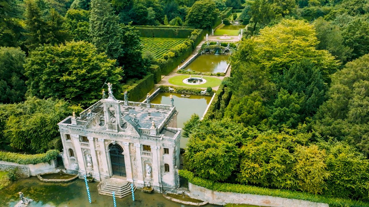 Luftaufnahme der barocken Gartenanlage von Valsanzibio mit einem ehemaligen Wasserzugang, umgeben von dichten Bäumen und gepflegten Hecken.