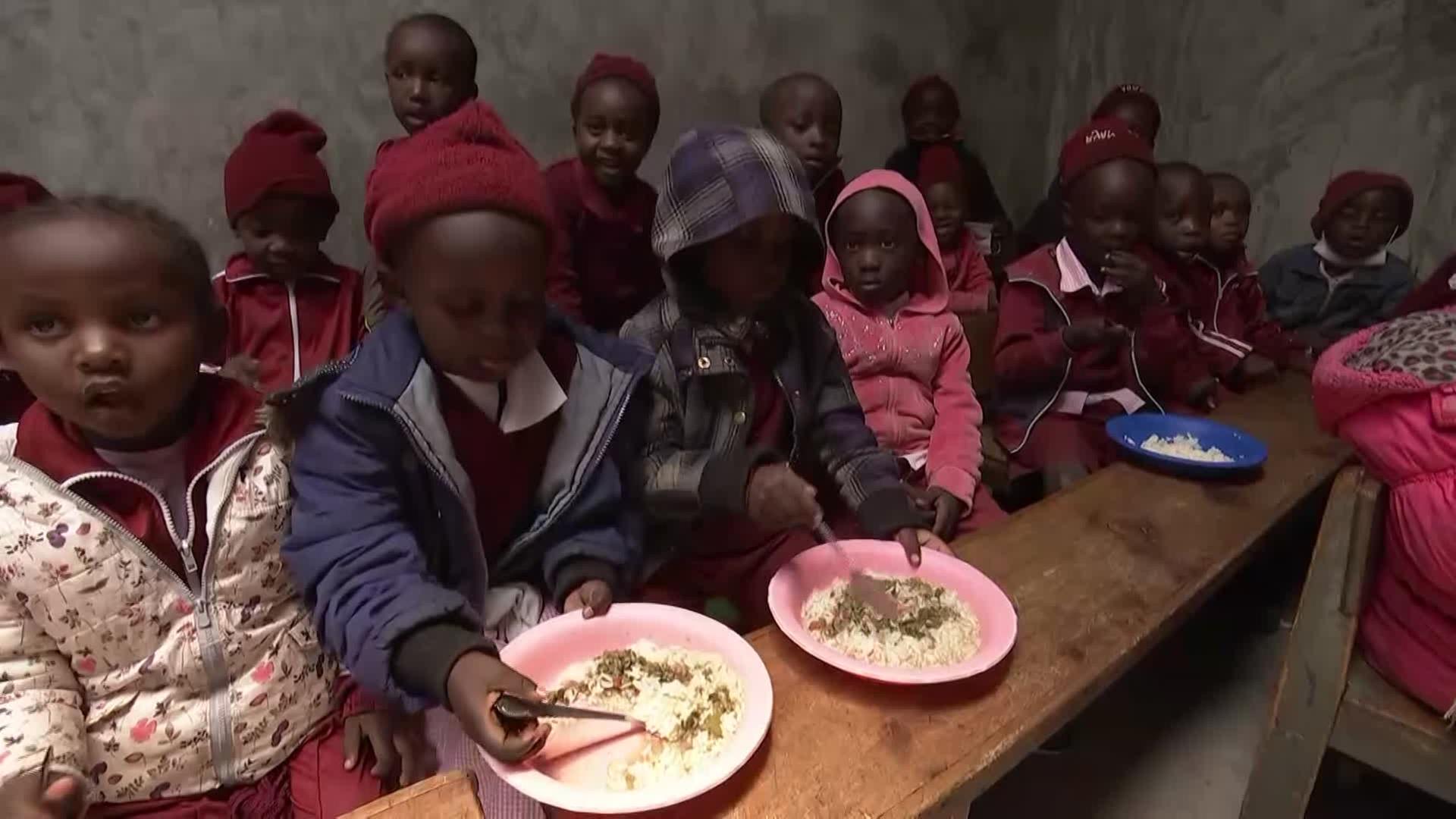Kinder bekommen in einer Einrichtung Essen ausgegeben.
