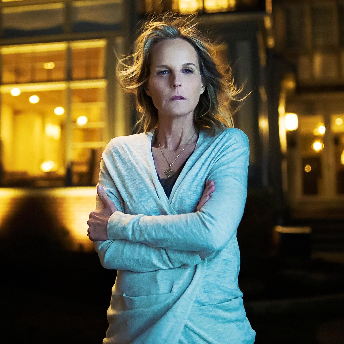 Eine Frau vor einem großen, luxuriösen Haus.