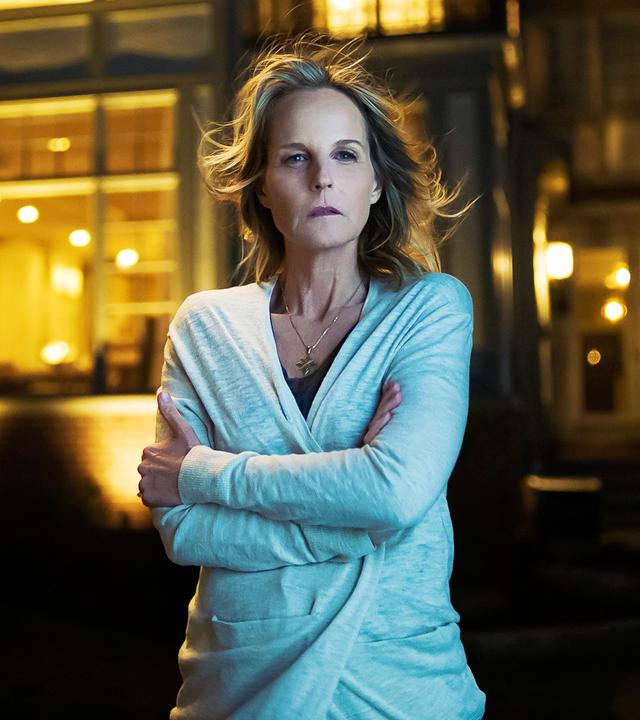 Eine Frau vor einem großen, luxuriösen Haus.