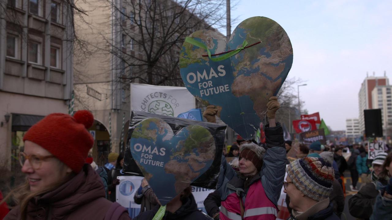 Demonstration, bei der zwei große Pappherzen hochgehalten werden, auf denen steht "Omas for future".