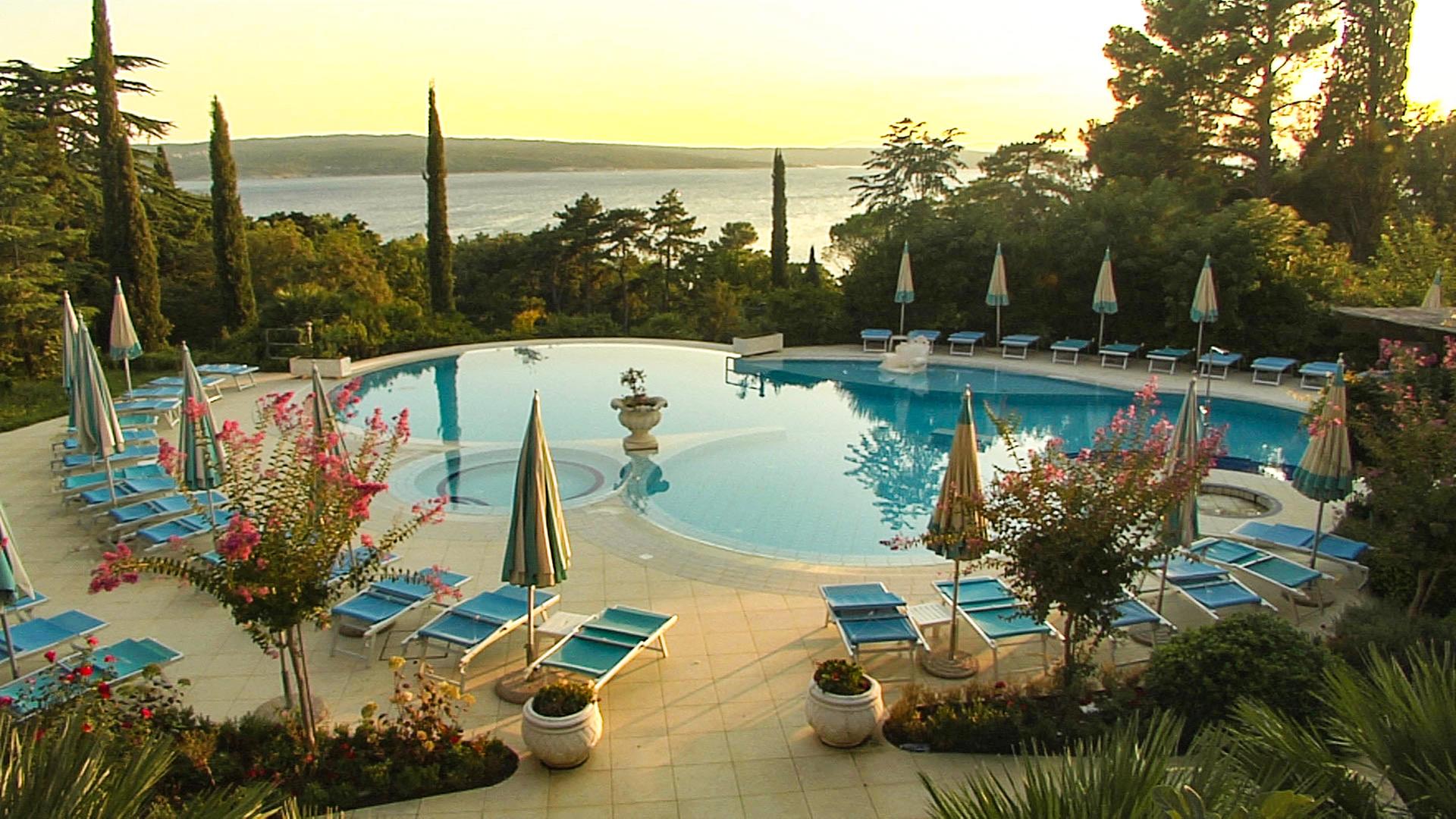 Blick auf einen Pool am Meer im Abendlicht