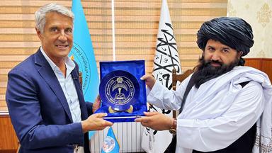 Enrique Steiger überreicht einem Vertreter der Taliban einen Ehrenpreis in einer offiziellen Zeremonie.