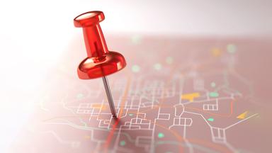 ein Nadelpin, der auf einer imaginären Landkarte steckt