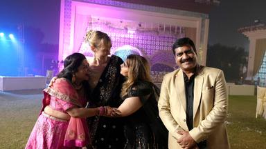 Drei Frauen und ein Mann in traditioneller Kleidung.