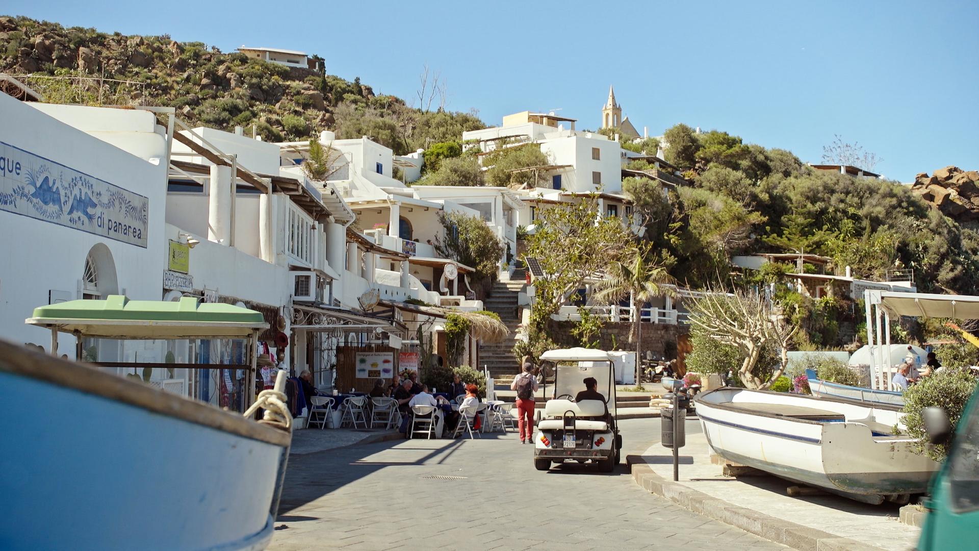 Aufnahme eines Hafenteils mit einem vorbeifahrenden Golfcarts. 