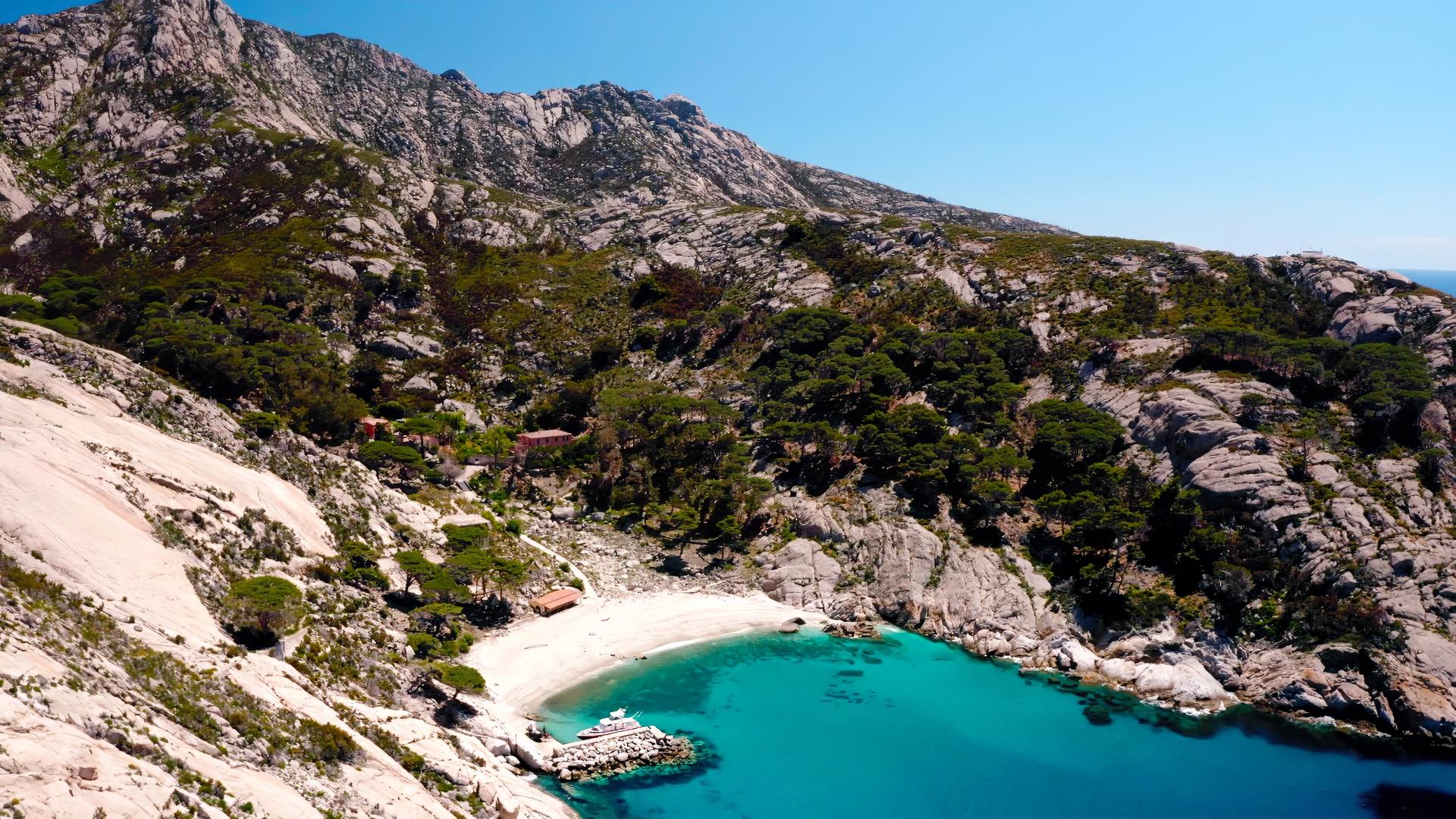 Ansicht eines kleinen geschützten Strands mit klarem Wasser.