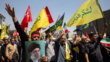 Männer demonstrieren mit iranischen Flaggen