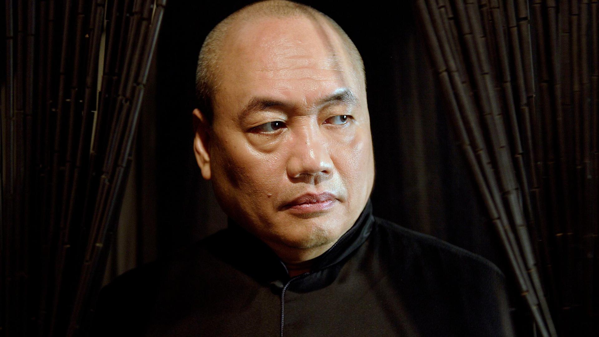 Ein Mann blickt ernst an der Kamera vorbei.