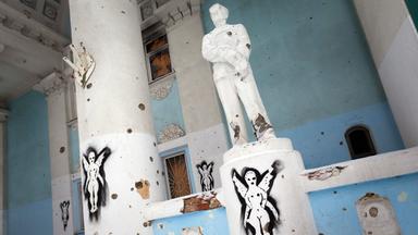 Statue und Säulen mit Einschusslöchern im Inneren des zerstörten Kulturhauses