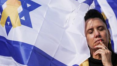 Frau mit geschlossenen Augen vor israelischer Fahne am Platz der Geiseln in Tel Aviv