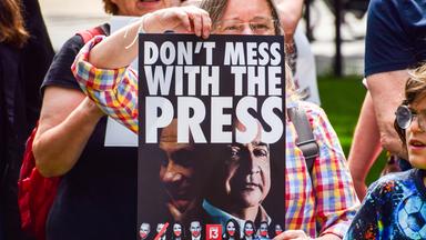 Eine Frau hält ein Plakat hoch, auf dem steht Don't Mess With the Press