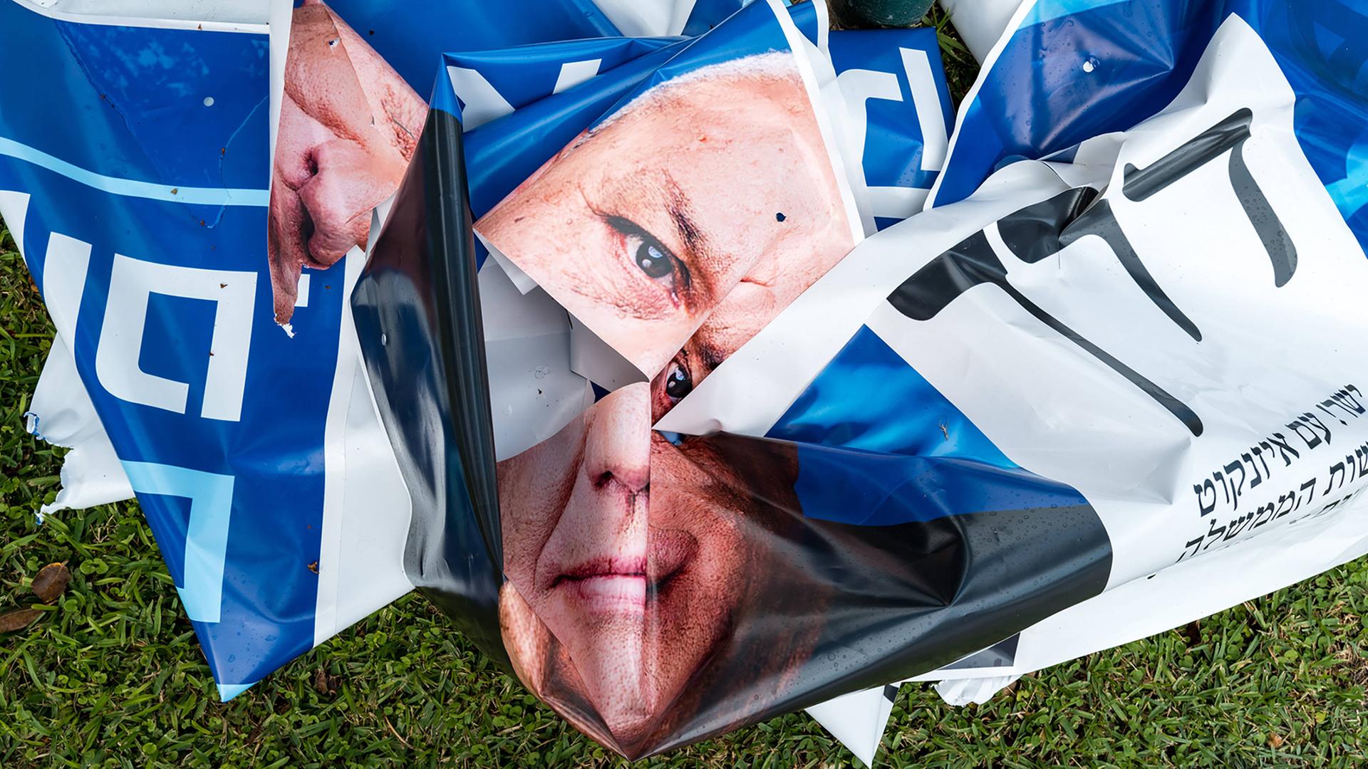 Zerknülltes Wahlplakat mit Bild eines Mannes liegt auf der Straße 