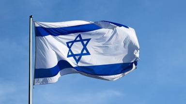 Die israelische Flagge - ein blauer sechseckiger Stern auf weißem Grund zwischen zwei blauen Balken - weht vor blauem Himmel.