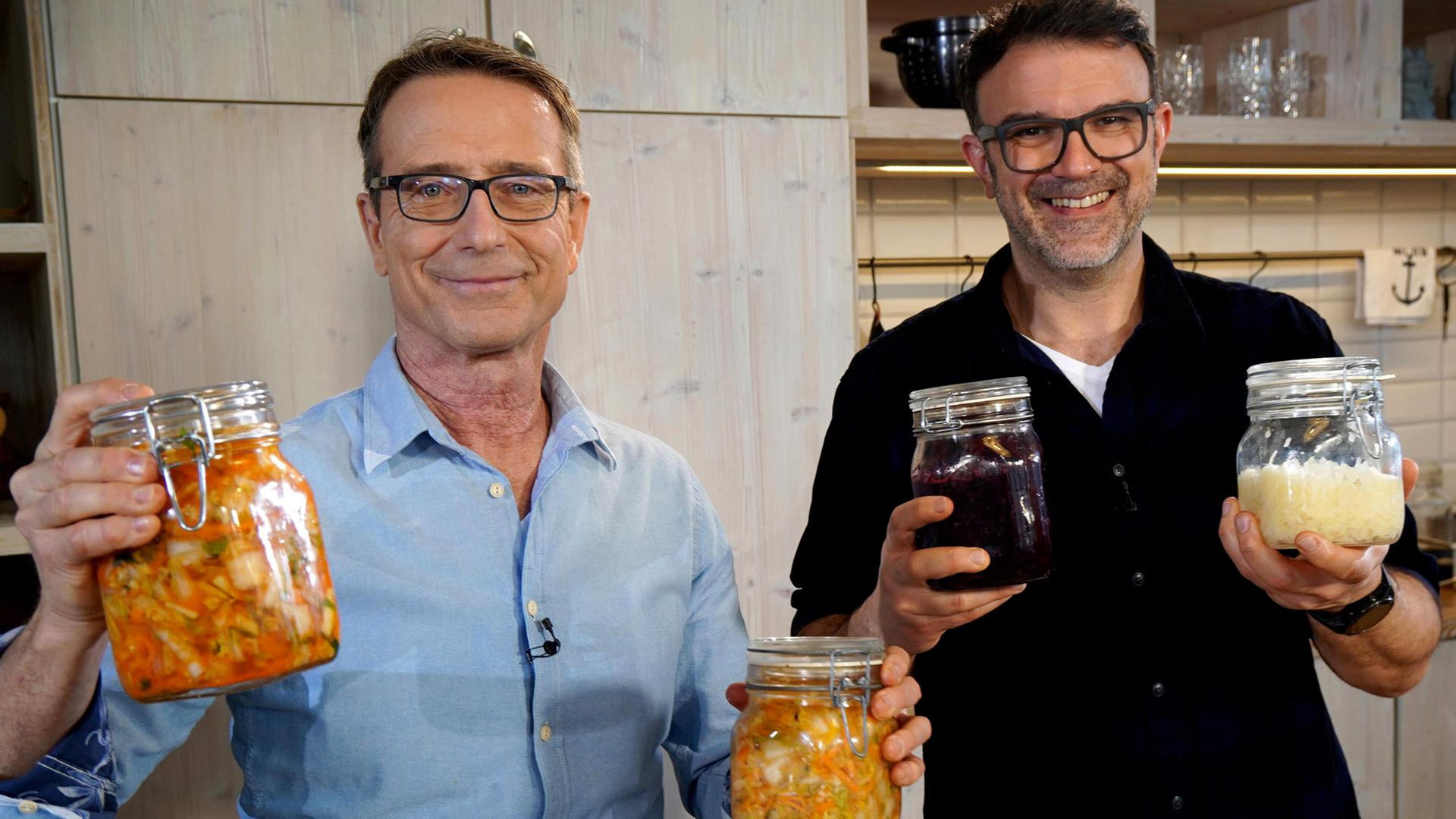 Dr. Matthias Riedl (li) und Tarik Rose mit gefüllten Einmachgläsern in den Händen