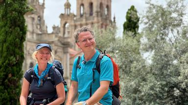 Eine Frau und ein Mann vor einer Kathedrale.