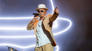 Ein Mann auf der Bühne singt in ein Mikrofon.
