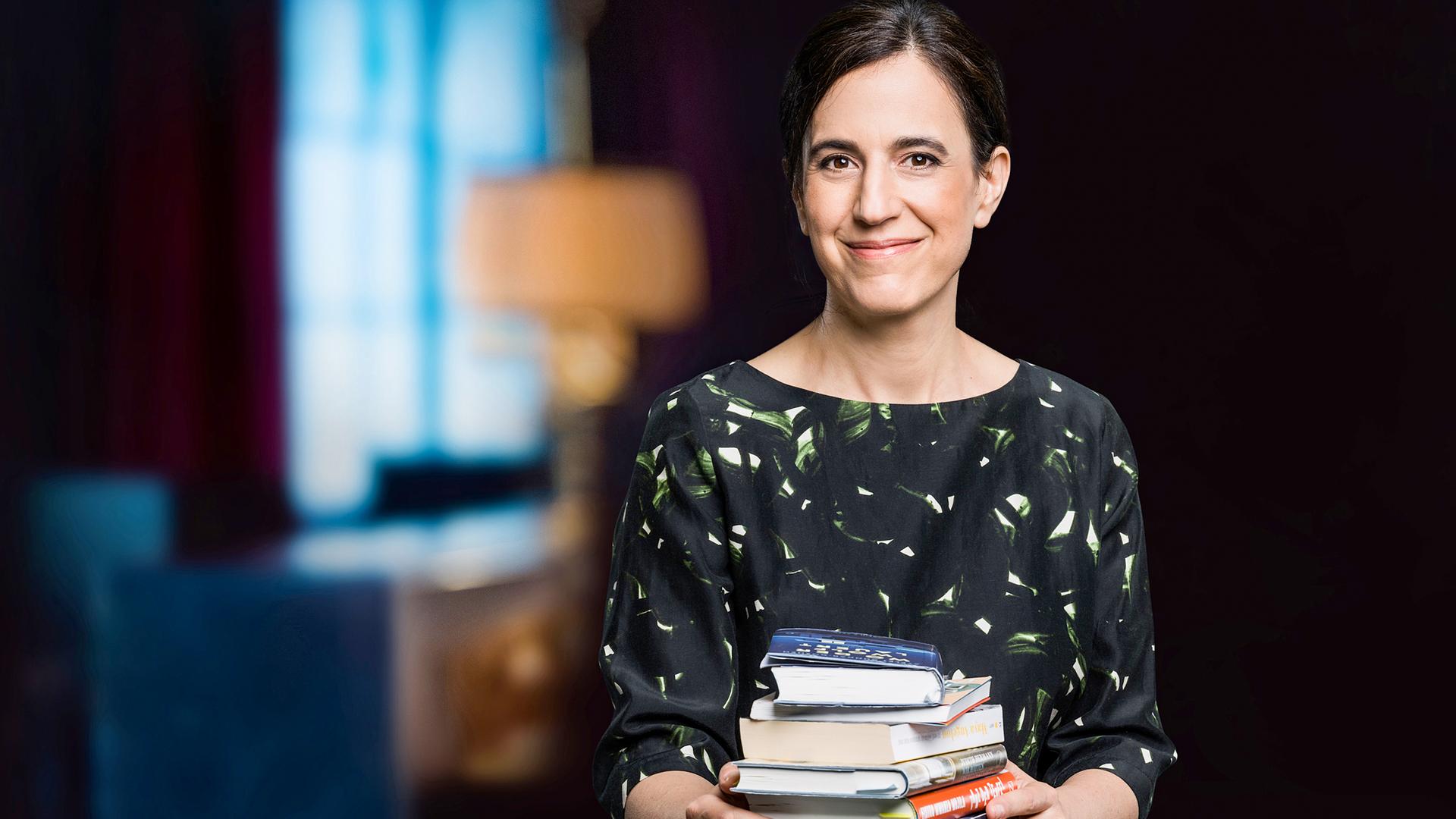 Lächelnde dunkelhaarige Frau mit Bücherstapel