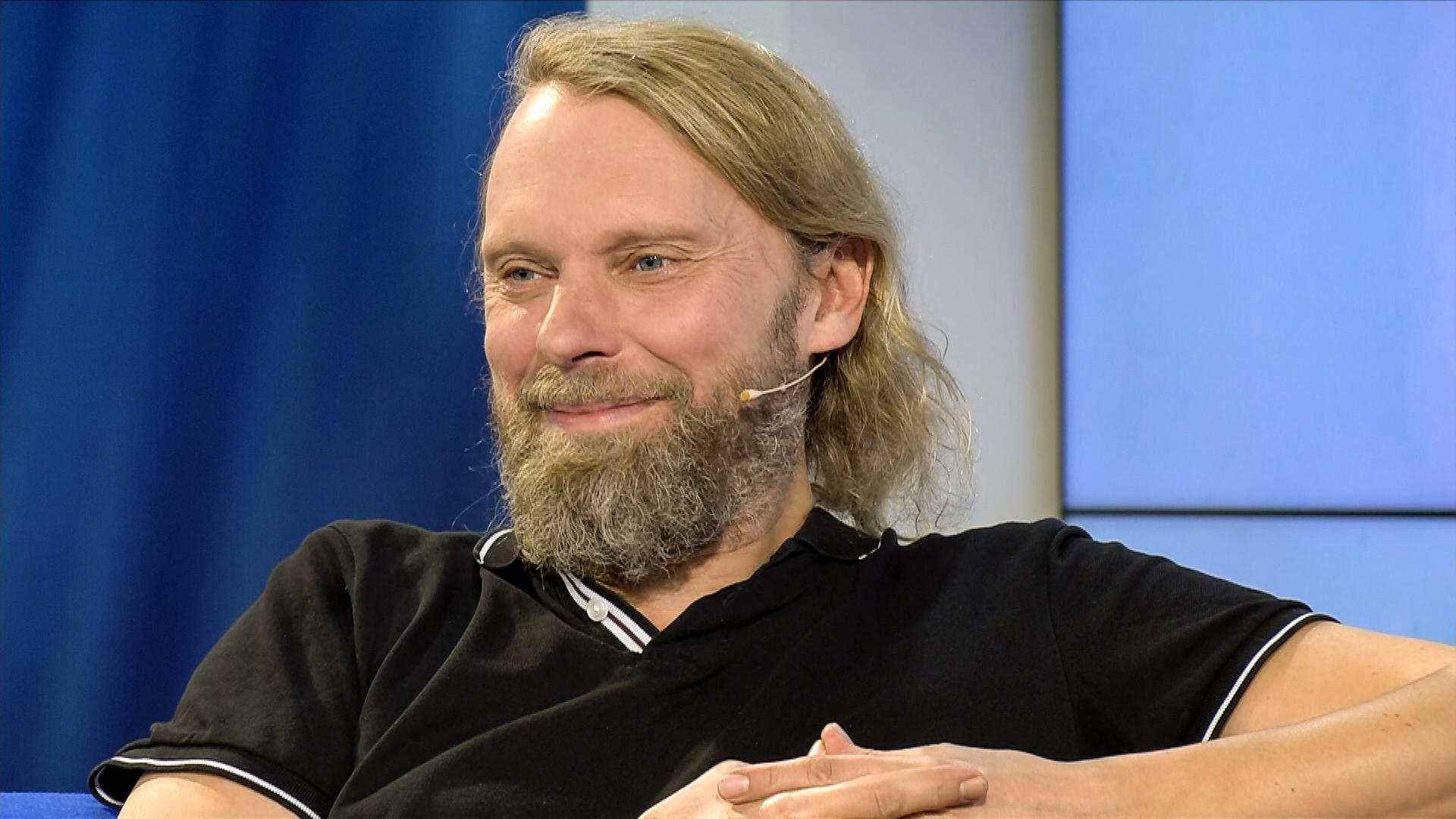 Mann mit blonden Haaren und Bart.