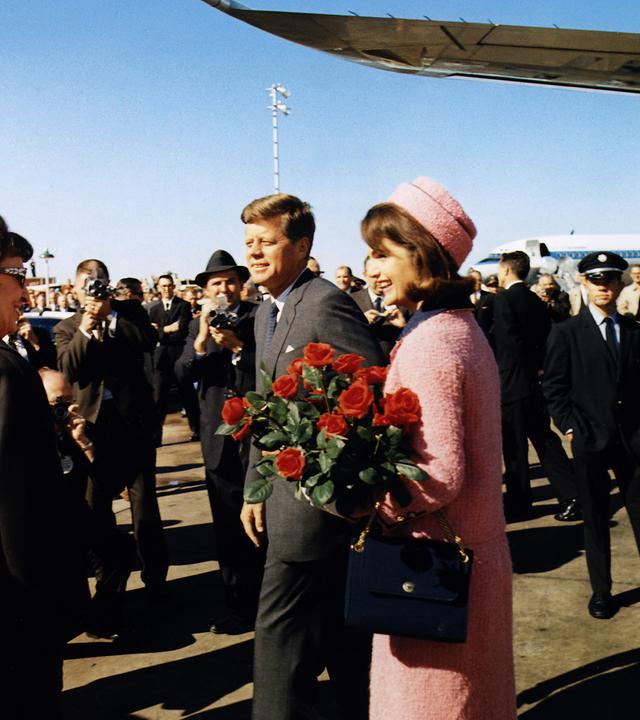Mann und Frau laufen über das Rollfeld, im Hintergrund steht das Flugzeug.