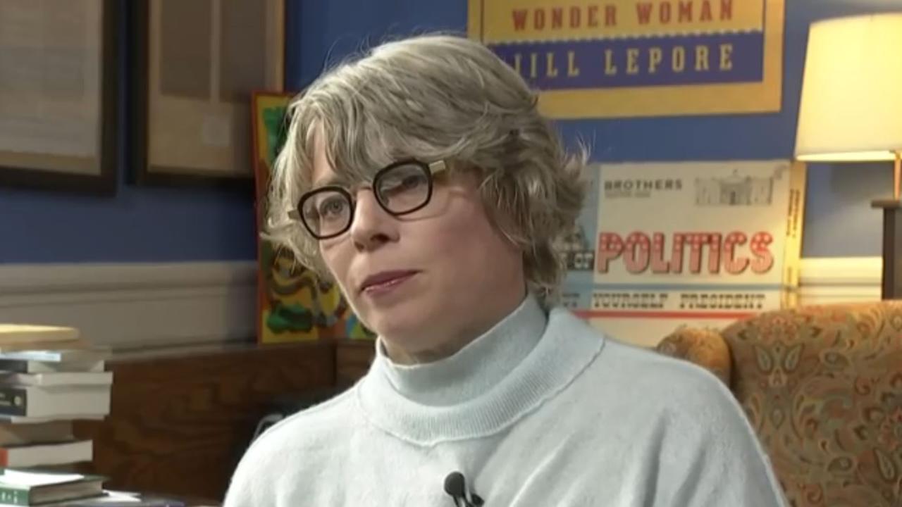 Frau mit schwarzer Brille und hellen Haaren mit angestecktem Mikrofon.