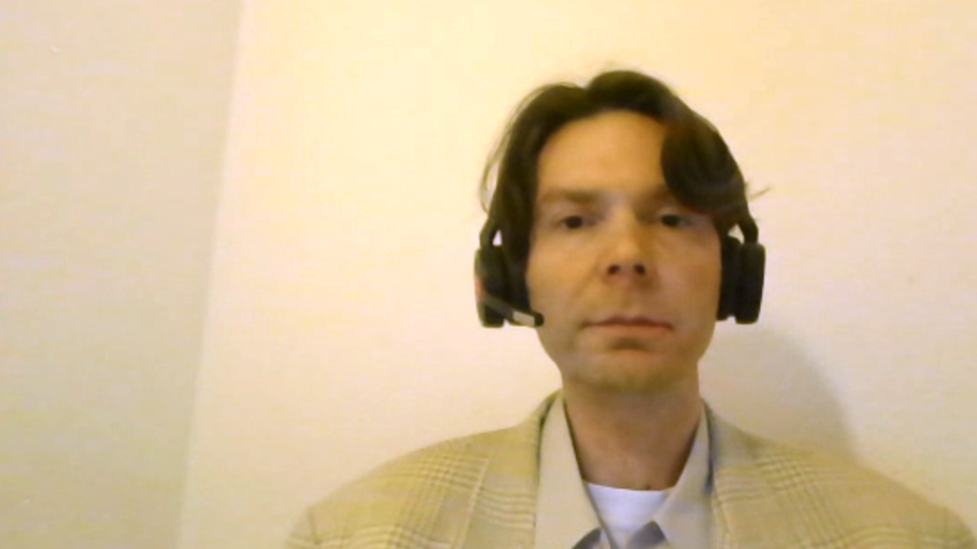 Ein Mann mit Headset schaut in die Kamera.