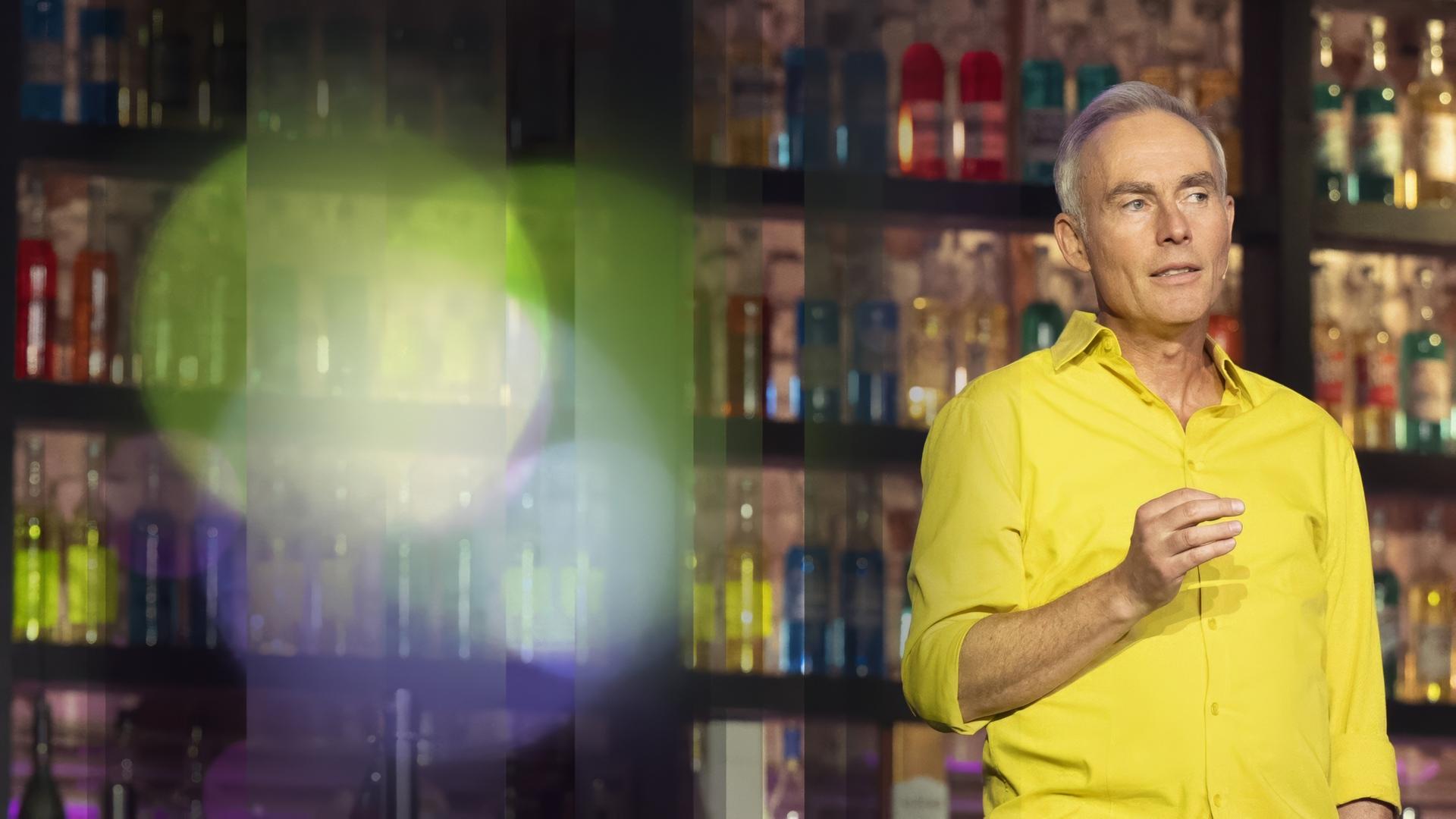 Johann König im gelben Hemd beim Moderieren.