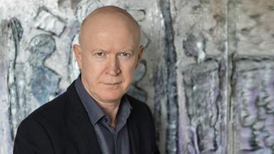 Porträtfoto eines Mannes, der ein Buch mit dem Titel "Hamas" vor sich hält.