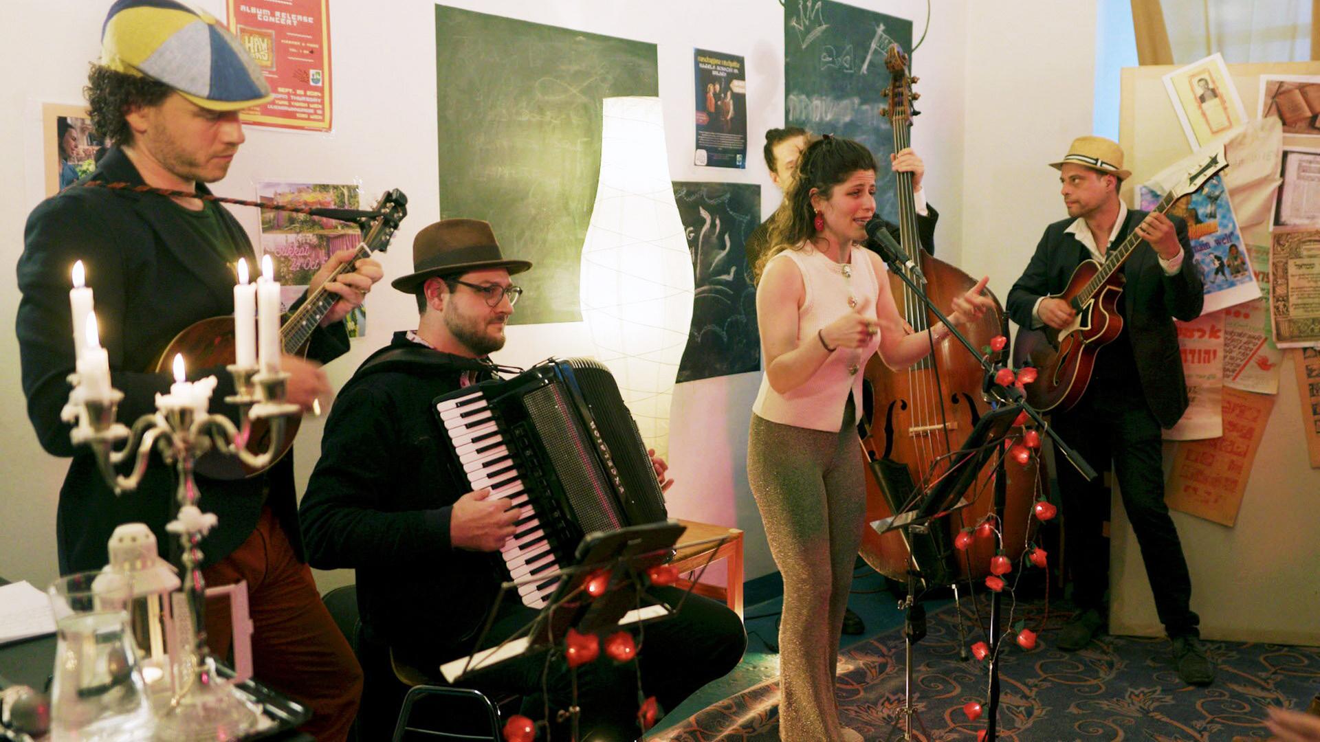 Vier Musiker mit ihren Instrumenten und eine Sängerin