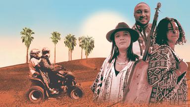 Porträt zweier Frauen und einem Mann vor einer Wüste mit Palmen. Daneben steht ein Motorrad mit zwei Menschen darauf. 