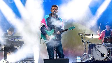 Man sieht eine Rockband auf der Bühne.