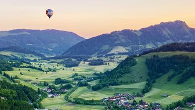 Heißluftballon über dem abendlichen Tannheimer Tal in Tirol