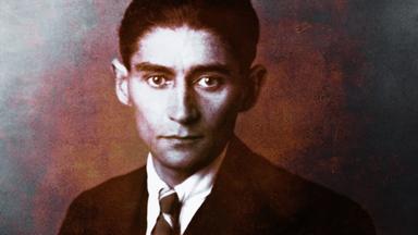 Ein junger Mann mit Jackett und Krawatte blickt ernst nach vorn