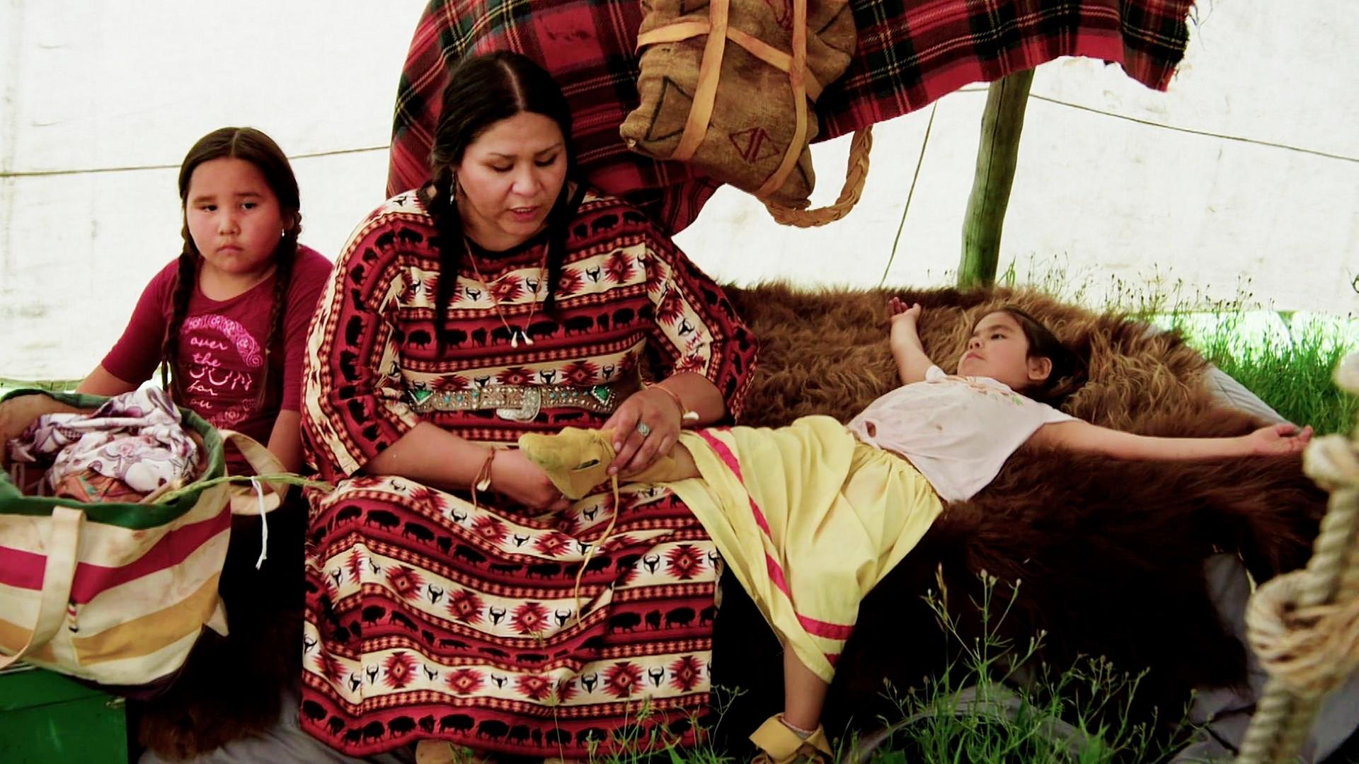 Angehörige der First Nations Blackfoot sitzen in einem Zelt