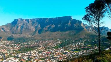 Eine dichtbesiedelte Stadt vor einem Bergkamm.