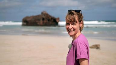 Nina Heins am Strand. Im Hintergrund das Schiffswrack der Cabo Santa Maria.