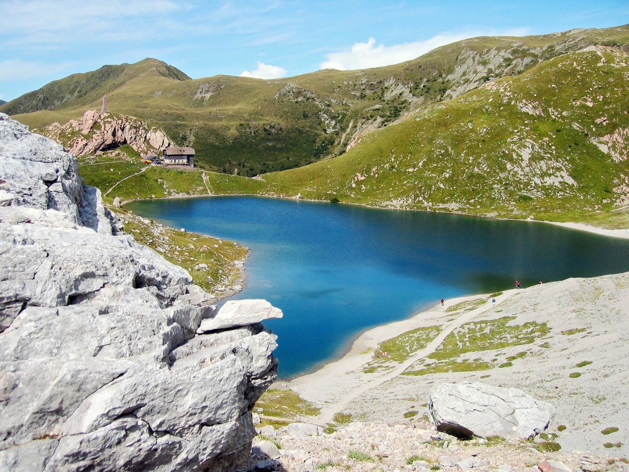 Ein See umgeben von grünen Bergen