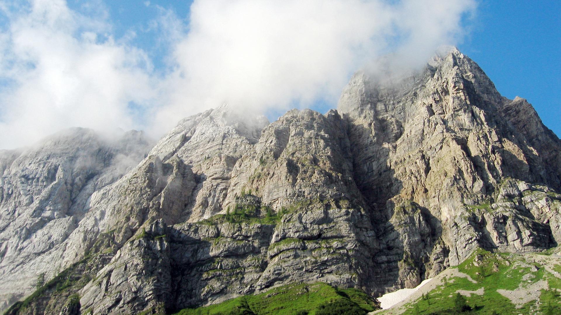 Wolken umgeben die Spitze einer Gebirgswand