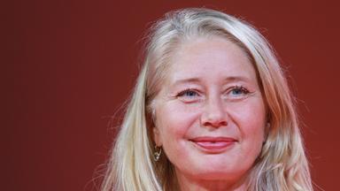 Porträtfoto einer jungen Frau mit langen blonden Haaren und blauen Aufen.