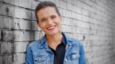 Frau in Jeansjacke vor Wand