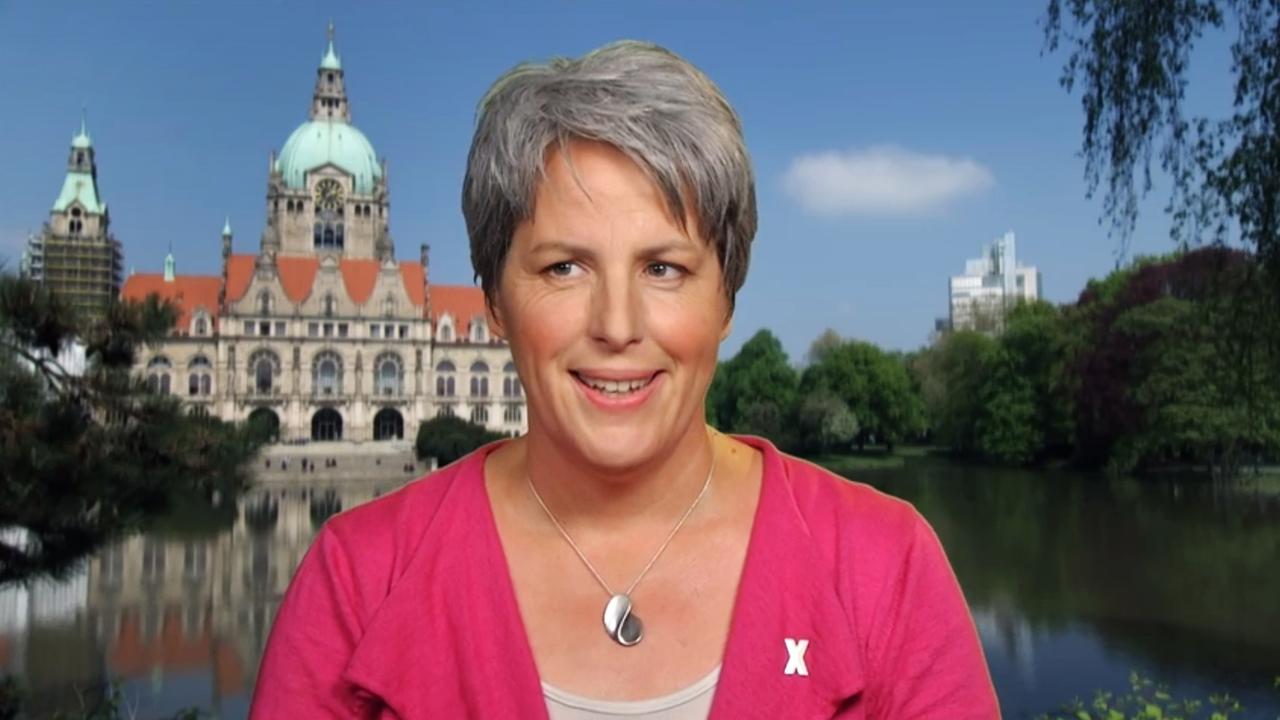 Frau mit kurzen grauen Haaren und pinkfarbenem Oberteil.