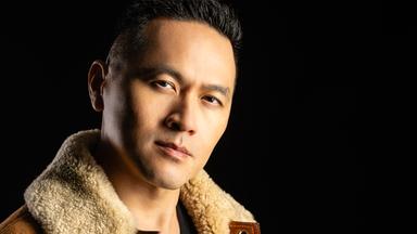 Porträtfoto eines jungen asiatischen Mannes mit an den Seiten sehr kurz geschorenen Haaren und Pelzjacke.