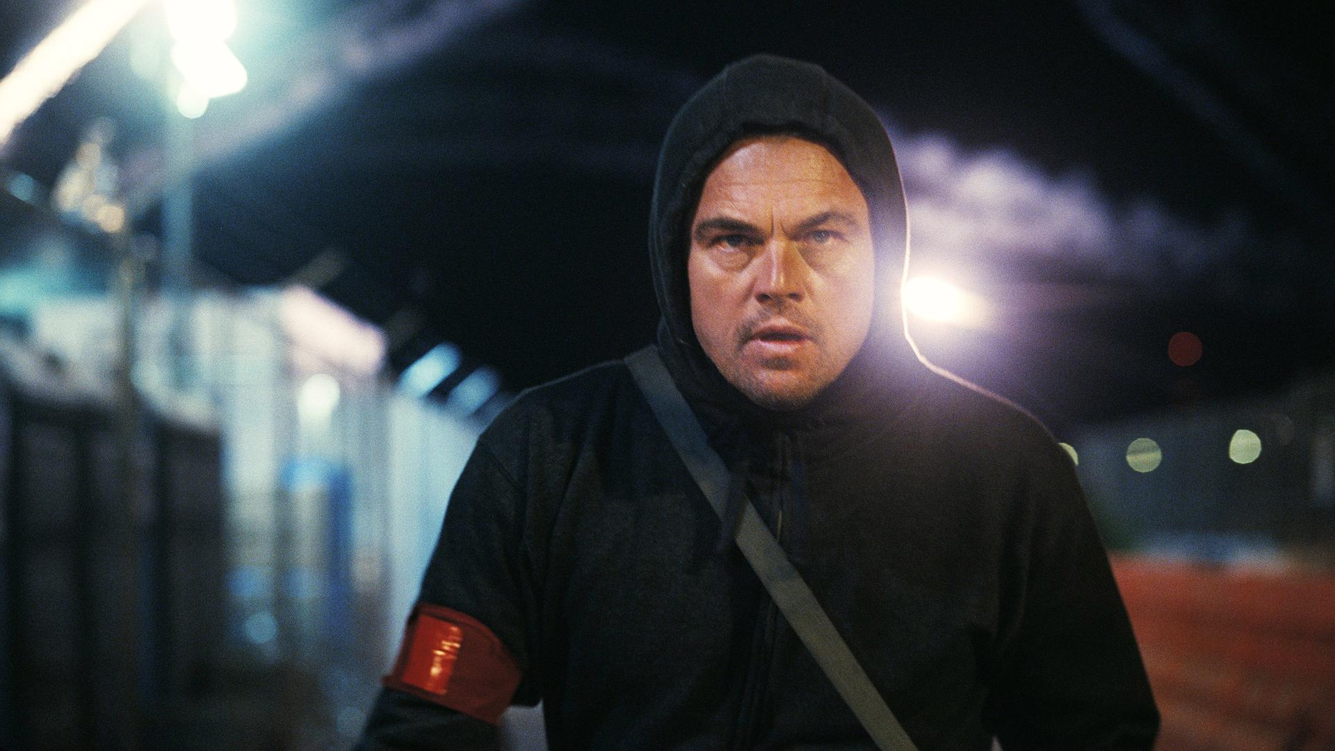 Ein Mann mit dunklem Kapuzenpulli in Dunkelheit im Gegenlicht