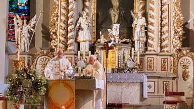 Zwei Pfarrer am Altar.
