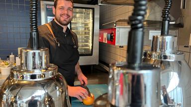 Ein junger Mann in einer Gastronomieküche.