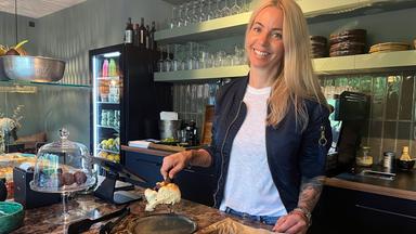 Eine blonde Frau in einem Deli.